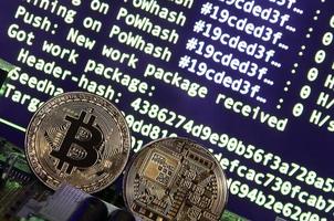 The digital process of cryptocurrency mining by using the GPUs. Bitcoins and video card on a working display and mining screen photo