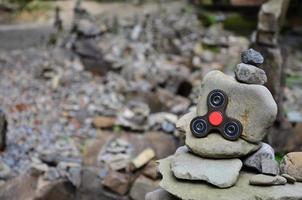 A wooden spinner lies on strange stone structures in the forest photo