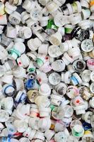 A large number of caps from cans of aerosol paint for graffiti. Smeared with colored paint nozzles lie in a huge pile photo