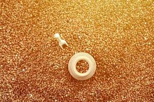 Background image of a large pile of buckwheat, in the middle of which lies a small jug and a wooden spatula for cereals photo