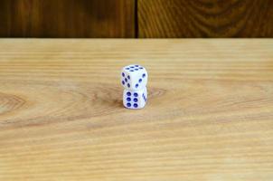 A few dice lies on the surface of natural wood. Items for generating numbers from one to six in the form of points that are painted on the side of cubes. The concept of gambling photo