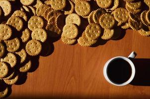 taza de café pequeña y galleta salada foto