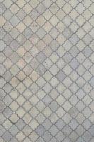 la textura de un mosaico rítmico hecho de baldosas de hormigón. imagen de fondo de una gran área de baldosas grises viejas y dañadas