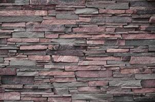 Texture of a stone wall from long and rough stones of different sizes and tones photo