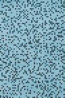 The texture of the wall, decorated with a mosaic of various small square tiles. Abstract pattern of ceramic tiles on the wall photo