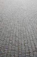 The texture of the paving slab paving stones of many small stones of a square shape under bright sunlight photo