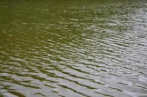 The texture of dark river water under the influence of wind, imprinted in perspective. Horizontal image photo