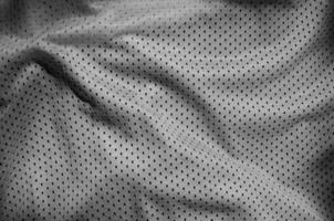 Grey sport clothing fabric texture background. Top view of grey cloth textile surface. Dark basketball shirt. photo