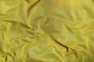 Sport clothing fabric texture background, top view of yellow cloth textile surface photo