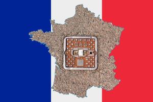 Outline map of France with the image of the national flag. Manhole cover of the gas pipeline system inside the map. Collage. Energy crisis. photo