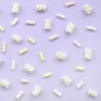 Colorful marshmallow laid out on violet paper background. pastel creative texture. minimal photo