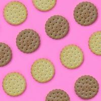 Pattern of a brown biscuits on a pink background. Trendy minimal concept of food and dessert. Abstract flat lay, top view photo