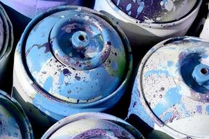 A lot of used blue metal tanks with paint for drawing graffiti photo