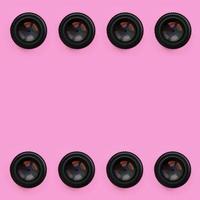 unas pocas lentes de cámara con una apertura cerrada yacen sobre un fondo de textura de papel de color rosa pastel de moda en un concepto mínimo. patrón abstracto de moda foto