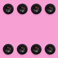 A few camera lenses with a closed aperture lie on texture background of fashion pastel pink color paper in minimal concept. Abstract trendy pattern photo