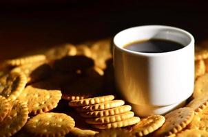 taza de café pequeña y galleta salada foto