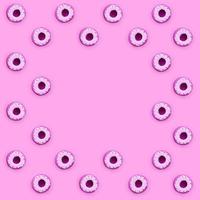 Many small plastic donuts lies on a pastel colorful background. Flat lay minimal pattern. Top view photo