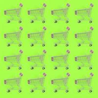 Shopping addiction, shopping lover or shopaholic concept. Many small empty shopping carts perform a pattern on a pastel colored paper background. Flat lay composition, top view photo