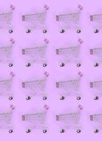 Shopping addiction, shopping lover or shopaholic concept. Many small empty shopping carts perform a pattern on a pastel colored paper background. Flat lay composition, top view photo