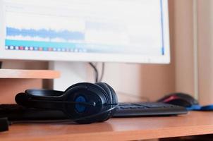 Big black headphones lie on the wooden desktop of the sound designer photo