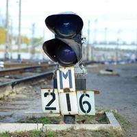 semáforo con luz azul ardiente. la intersección de las vías del tren foto