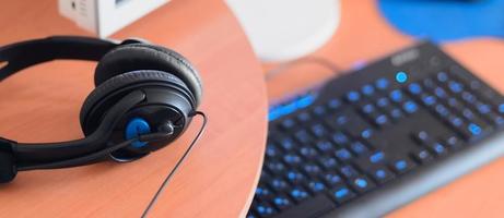 Big black headphones lie on the wooden desktop of the sound designer photo