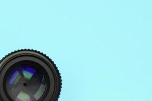 Camera lens with a closed aperture lie on texture background of fashion pastel blue color paper photo