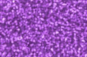 Blurred purple decorative sequins. Background image with shiny bokeh lights from small elements photo