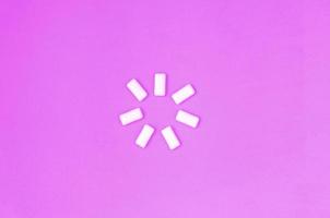 A few chewing gums lie on texture background of fashion pastel purple color paper photo