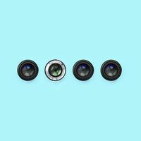 A few camera lenses with a closed aperture lie on texture background of fashion pastel blue color paper photo