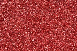 Crimson red decorative sequins. Background image with shiny bokeh lights from small elements photo