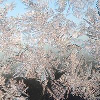 Snowflakes frost rime macro on window glass pane photo