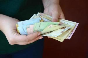 Female hands counts big amount of ukrainian money during salary period in Ukraine photo