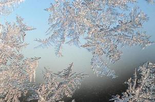 Snowflakes frost rime macro on window glass pane photo