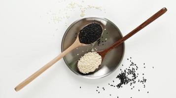 Black and white sesame seeds in a spoons photo