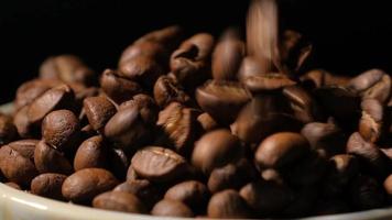 rallentatore di chicchi di caffè tostati che cadono. semi di caffè biologico. video