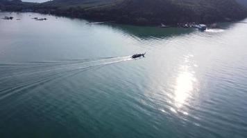 Aerial view from a drone of Thai traditional longtail fishing boats sailing in the sea. Top view of a fast moving fishing boat in the ocean. video
