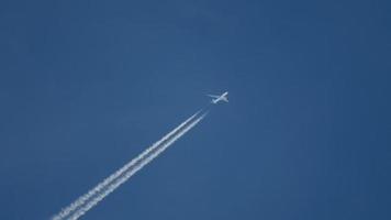 ziviles Passagierflugzeug überquert den Himmel und hinterlässt eine Rauchfahne. tourismus- und reisekonzept video