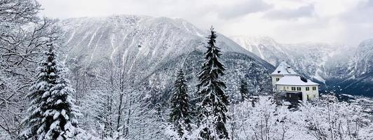 Panorama of Hallstatt Winter snow mountain landscape through the forest in upland valley leads to the old salt mine of Hallstatt, Austria photo