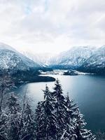 Scenery of Hallstatt Winter snow mountain landscape valley and lake through the forest in upland valley leads to the old salt mine of Hallstatt, Austria Vertical photo