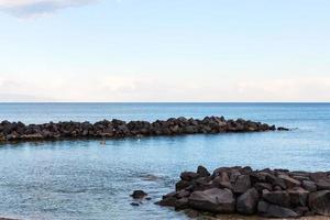 stones breakwater near beach of Giardini Naxos photo
