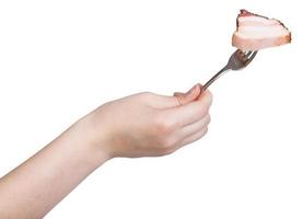 hand holds fork with impaled piece of bacon photo