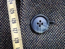 measuring tape and buttoned button on tweed jacket photo