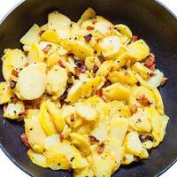 fried potatoes with cracklings in frying pan photo