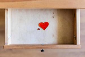 pequeños y grandes corazones de cristal en un cajón abierto foto
