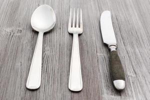 flatware set from knife, fork, spoon on wood board photo