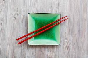 above view square saucer with chopsticks on gray photo