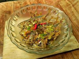 Padang special yellow spiced sea fish with whole chili photo
