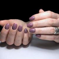manicura morada en las uñas. diseño de uñas moradas en los dedos. foto