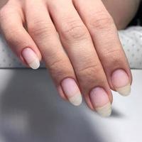 manicura femenina profesional en uñas largas en la foto